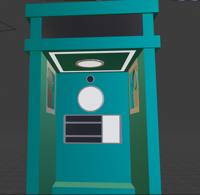 Image description: A teal metal phone booth. The door was removed from it to show a clear view of the interior; The walls to the sides have small square windows on them, and the back wall has a round screen with a small camera above it, and a control panel below it.